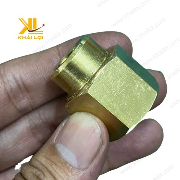Tay người cầm một chiếc măng song thau giảm, chuẩn bị cho việc lắp đặt.